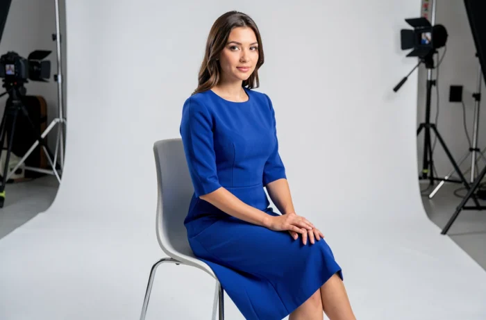 Jeune mannequin en robe midi bleue cobalt lors d'une séance photo éditoriale en studio, illustrant le parcours professionnel dans l'industrie de la mode